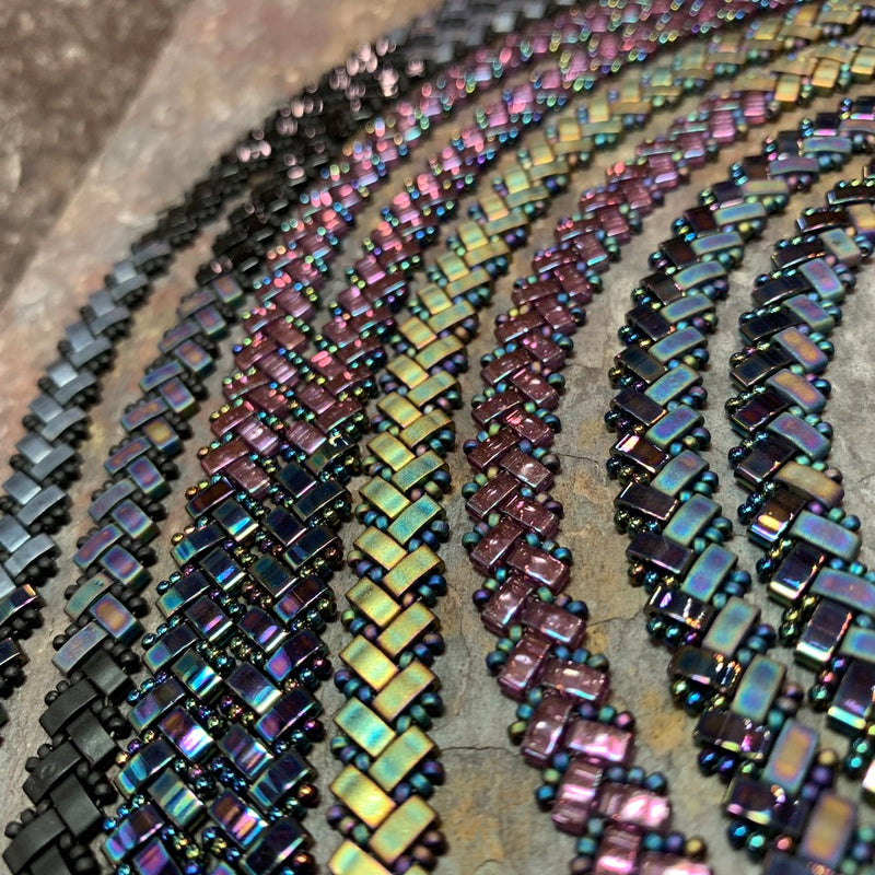 Close-up of beaded jewelry with iridescent colors on a textured surface