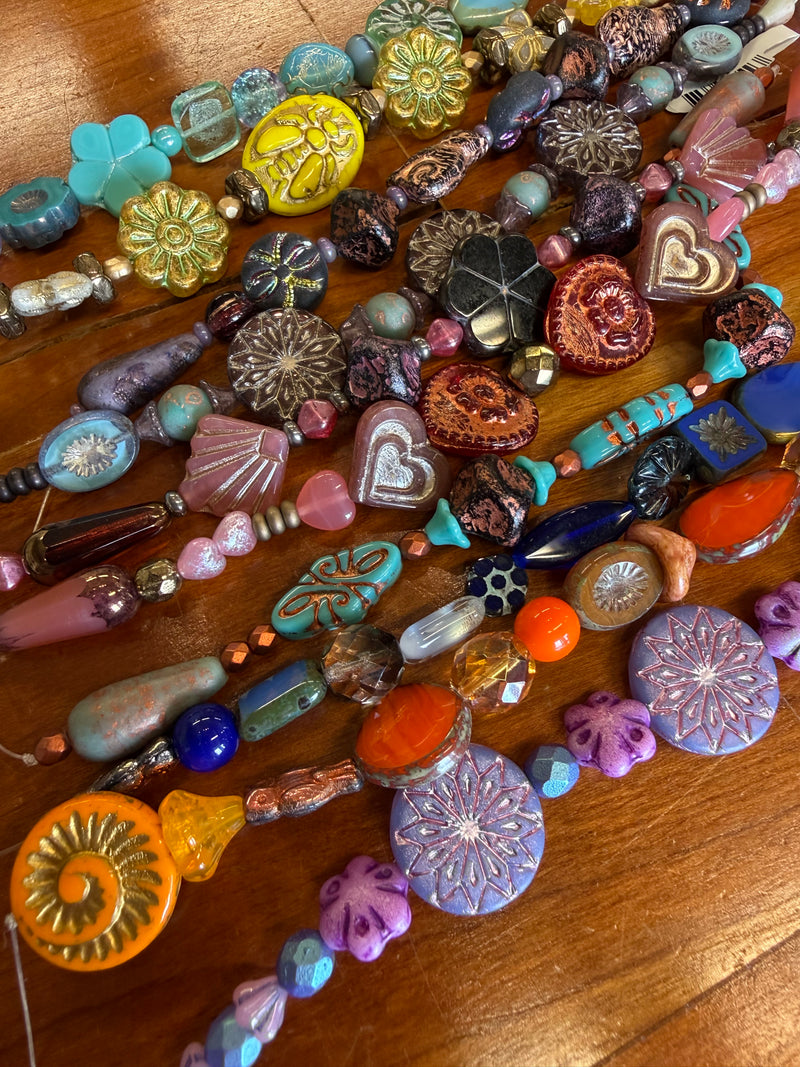Assorted colorful beads on a wooden surface