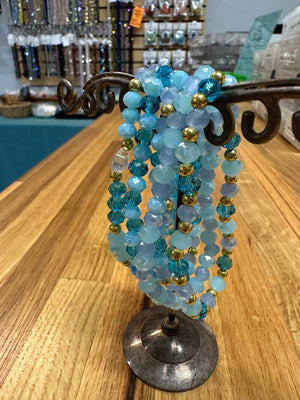 Blue beaded bracelet set on a stand with a store background