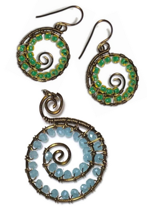 Set of spiral-shaped earrings with green and blue stones on a white background